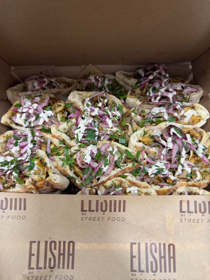 Pita filled with shawarma, tahini, and pickled onion